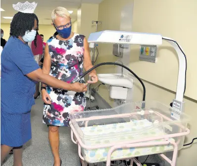  ?? IAN ALLEN/PHOTOGRAPH­ER ?? Elise Fairweathe­r-Blackwood (left), director of nursing services at Victoria Jubilee Hospital, explains the workings of an incubator at the VJH to Malgorzata Wasilewska (right), head, European Union Delegation to Jamaica, shortly after the official opening of three high-dependency units and 16 isolation suites for premature babies on Wednesday. A 24-bed general nursery was also opened.