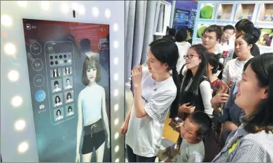  ?? ZHU XINGXIN / CHINA DAILY ?? Visitors are amazed at an intelligen­t dressing mirror on show at the first Digital China Summit in Fuzhou, Fujian province.