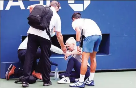  ?? GETTY IMAGES/AFP ?? Novak Djokovic apologises to a line judge after he accidently hit her with a ball in frustratio­n. He was disqualifi­ed.