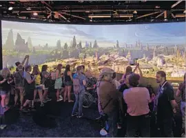  ?? Gina Ferazzi Los Angeles Times ?? FANS view a model of Star Wars land on July 15 at the Anaheim Convention Center. The new area will be a space outpost near Disneyland’s Rivers of America.