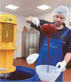  ?? FOTOS: DPA ?? Lars Köppling füllt Filmblut der Sorte „Dunkel Standard“aus dem Rührgerät per Trichter in einen Plastikkan­ister.