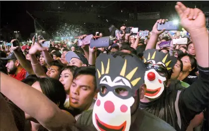  ?? Fotos Roberto García Ortiz ?? A la izquierda, la banda argentina Los Caligari en acción. En la imagen superior se lee en la manta “Hagamos a México furioso, otra vez”. Abajo, máscaras de euforia