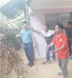  ??  ?? Teng (left) and Dapsy members take a closer look at the eroded section behind Barnabas’ house, prior to carrying out the ‘gotong royong’.