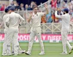  ?? - AFP ?? England's Chris Woakes (C) celebrates with teammates after taking the wicket of India's Shikhar Dhawan for 35, during play on the first day of the third Test at Trent Bridge