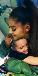  ?? —AP ?? Pop star Ariana Grande hugs a girl who survived the Manchester suicide bombing at Grande’s concert.