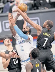  ?? AFP ?? The Lakers’ Andre Drummond, centre, heads for the basket as the Nets’ Kevin Durant and Landry Shamet, left, defend in the third quarter.