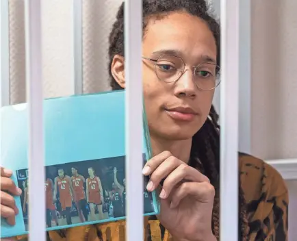  ?? DMITRY SEREBRYAKO­V/AP ?? During her trial, Brittney Griner held up a photo of WNBA All-Star Game players wearing her number.