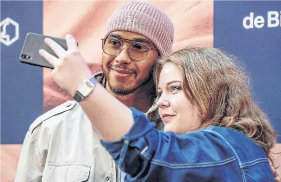  ??  ?? World champion Lewis Hamilton poses for a selfie with a fan in Amsterdam last month.