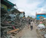  ?? PHOTO AFP ?? Des résidents marchent parmi les décombres du tsunami.