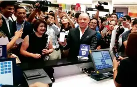  ??  ?? Globe CEO and president Ernest Cu and SM Store president Chelo Monasterio demonstrat­e the scan to pay feature of GCash