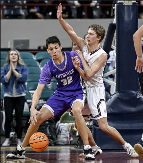  ?? AARON ONTIVEROZ — THE DENVER POST ?? Lutheran’s Kade Spackman, left, backs down Alamosa’s Kade Jones during the second half of their Great 8 Colorado state tournament game Friday at Denver Coliseum.