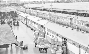  ??  ?? Employees on a platform load boxes into a luggage coach of a Green Line Express train operated by Pakistan Railways between Islamabad and Karachi in Rawalpindi. — Bloomberg photos by Asim Hafee