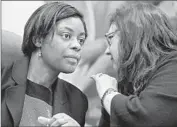  ?? Don Bartletti Los Angeles Times ?? PUC COMMISSION­ERS Carla J. Peterman, left, and Catherine J.K. Sandoval confer at the hearing on the proposed Comcast-Time Warner Cable merger.