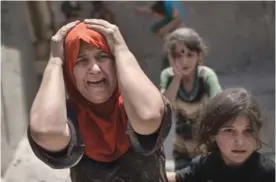  ??  ?? MOSUL: A woman screams while fleeing with her family through a destroyed alley, as Iraqi Special Forces continue their advance against Islamic State militants, in the Old City of Mosul. — AP