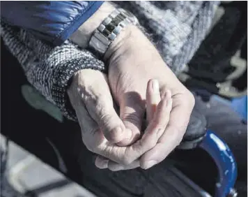  ?? Ferran Nadeu ?? Un hombre coge la mano a su madre, enferma de alzhéimer.