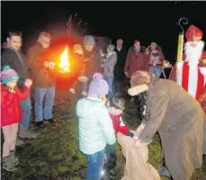  ?? FOTO: BRIGITTE GEISELHART ?? Prima ist die Stimmung bei der „Ailinger Waldweihna­cht“auf dem Horach. Und die Kinder werden von Nikolaus und Knecht Ruprecht mit einer süßen Überraschu­ng belohnt.