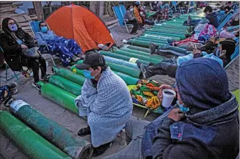  ?? — AFP file photo ?? People camp as they wait to refill empty oxygen cylinders in Villa el salvador, on the southern outskirts of Lima, amid the Covid-19 coronaviru­s pandemic.