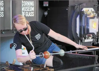  ?? CHARLES PRITCHARD — ONEIDA DAILY DISPATCH ?? Heather Spiewak molds and shapes glass on the Corning Museum of Glass’s GlassBarge on Saturday, July 7, 2018.