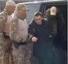  ?? Reuters ?? Trevor Reed is escorted to a plane in Moscow by Russian security officers as part of the prisoner swap