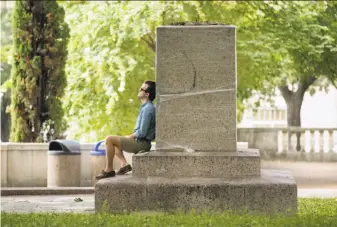  ?? Jay Janner / Austin American-Statesman ?? Edwin Bryan Robert Jr. sits at the base of a pedestal after a statue of Confederat­e Gen. Robert E. Lee was removed on the campus of the University of Texas at Austin.