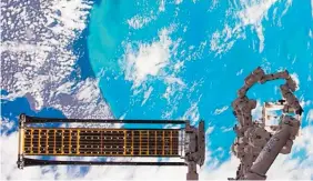  ?? COURTESY OF DEPLOYABLE SPACE SYSTEMS ?? The ROSA solar array is deployed on the robotic arm of the Internatio­nal Space Station, where it was tested in June 2017.