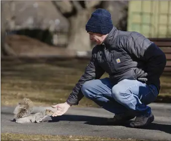  ?? LIBBY O’NEILL — BOSTON HERALD ?? Harry Townsend from Saco, Maine offers a peanut to a squirrel at Public Garden.