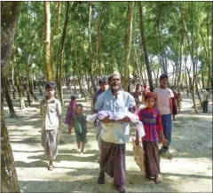  ?? MUNIR UZ ZAMAN/AFP ?? A Myanmar Rohingya refugee carries the body of a baby before his burial in a refugee camp in Bangladesh on November 26.