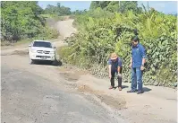  ??  ?? TINJAU: Dennis meninjau keadaan jalan balak di salah satu kawasan di Telang Usan.