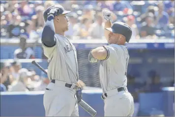  ?? Tom Szczerbows­ki / Getty images ?? Brett Gardner of the Yankees, right, is congratula­ted by Aaron Judge after hitting a solo home run to lead off the first inning of the Yanks’ 8-5 win against the Blue Jays Saturday in toronto.