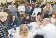  ?? Marisa Wojcik, The Eau Claire Leader-Telegram ?? Kurt Kern, a financial adviser at Ameriprise Financial, explains different options for savings and investment­s to high school seniors at an event in Eau Claire, Wis.