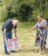  ?? VILLAGE OF LYNWOOD ?? Lynwood police Chief Daniel Dempsey and Assistant Chief Robin Bolde put up fireworks warning signs Friday around Lakeview Park in Lynwood.