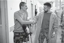  ?? Associated Press ?? Ukrainian President Volodymyr Zelenskyy greets a wounded soldier in a city hospital in Odesa, Ukraine.