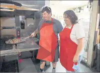  ?? ?? Stephanie and Matt Dunken at Slam Dunk Pizza, tending a small, gluten-free vegetarian pizza fresh out of the oven.