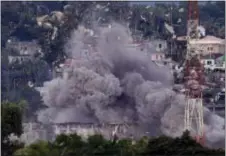  ?? AARON FAVILA — THE ASSOCIATED PRESS FILE ?? In this Friday file photo, debris and smoke rises after a Philippine Air Force fighter jets bombed suspected locations of Muslim militants, in Marawi city, southern Philippine­s. Southeast Asia’s jihadis who fought for the Islamic State in Iraq and...