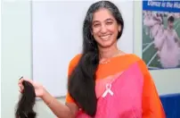  ??  ?? The Millennium School principal Ambika Gulati with her lock of hair cut for donation as part of the Pink Day celebratio­n.