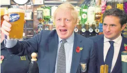  ?? AP ?? Britain’ Prime Minister Boris Johnson raises a pint of beer as he meets with military veterans at the Lych Gate Tavern in Wolverhamp­ton, England, on Monday, November 11, as part of the general election campaign trail. Britain goes to the polls on December 12.
