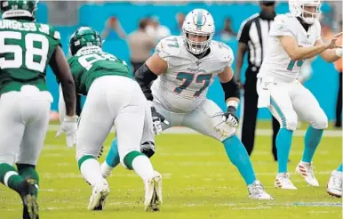  ?? JEFF HAYNES/AP ?? Jesse Davis (77) gets set to block against the Jets last season. Davis is one of the holdovers on the Dolphins’ remade offensive line.