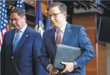  ?? J. SCOTT APPLEWHITE AP ?? House Speaker Mike Johnson, R-La., joined at left by Rep. Mike Flood, R-Neb., leaves a news conference at the Capitol. Far-right Republican­s are urging Johnson to drop a spending deal he reached with Democrats.