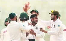  ?? AFP ?? Bangladesh players congratula­te Mehidy Hassan (second from right) after the dismissal of the West Indies’ Devendra Bishoo during the third day of the second Test.