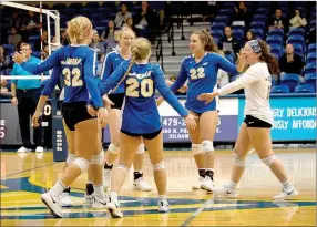  ?? Photo courtesy of JBU Sports Informatio­n ?? The John Brown volleyball team celebrates after scoring a point against Oklahoma Panhandle State on Saturday at Bill George Arena.