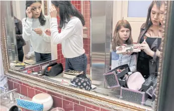  ??  ?? REFLECTING WELL: Chazzie, centre, watches Gia and Nicole put on makeup before heading outside to explore New York City, on a visit to speak about the GenderCool Project on NBC’s ‘Megyn Kelly Today’.