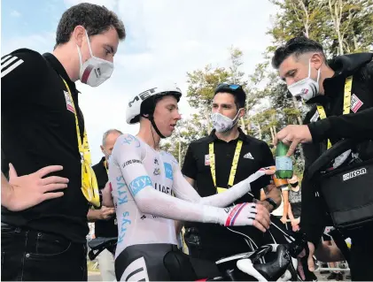  ?? Photo: ASO/Alex Broadway ?? Tour de France champion Tadej Pogacar consults SA’s Dr Adrian Rotunno, centre, and other team helpers.