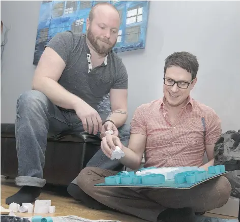  ?? GORD WALDNER ?? Ryan Prafke, left, with husband Ryan Dignan, work on an art project in their Saskatoon home. The pair are looking for a surrogate to carry their baby.