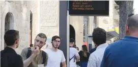  ?? (Marc Israel Sellem/The Jerusalem Post) ?? COMMUTERS CHECK an updates board at a bus stop in Jerusalem earlier this week.