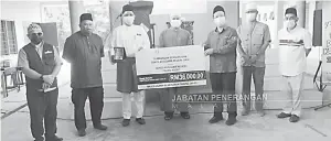  ??  ?? SUMBANGAN: Arifin (tengah) menyampaik­an sumbangan bernilai RM36,000 kepada Sekolah Agama Negeri Pekan Kudat.