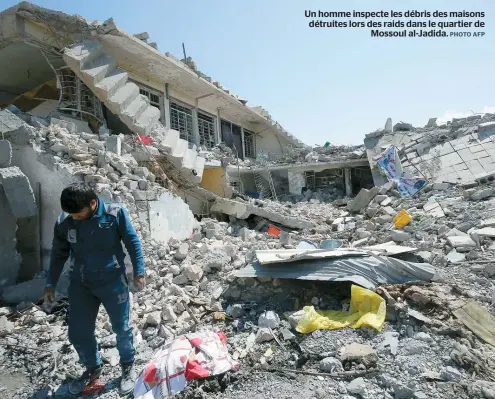  ??  ?? Un homme inspecte les débris des maisons détruites lors des raids dans le quartier de Mossoul al-Jadida.