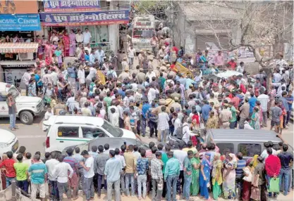  ??  ?? Pedestrian­s gathered around the house in Burari Village after news of the dead family spread.
