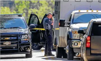  ?? CONTRIBUTE­D BY VILLA RICA POLICE ?? A Carroll County sheriff’s deputy waits as the GBI investigat­es the scene on Whitworth Road at Highway 61 after Monday’s chase. “It could have been a lot worse, and we’re thankful,” said Sheriff Terry Langley, who called the incident “horrific.” “We pray for the speedy recovery of those officers.”