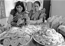  ??  ?? Two housewives showing how to make the traditiona­l Indian snack, murukku for this coming Deepavali. - Bernama photo