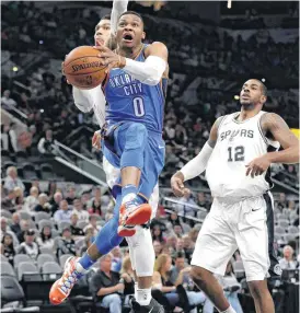  ?? [AP PHOTO] ?? Oklahoma City Thunder guard Russell Westbrook drives to the basket past San Antonio Spurs defenders Danny Green and LaMarcus Aldridge during Friday’s game in San Antonio. The Spurs won, 104-101.